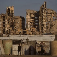 Palestinians walk past tents sheltering displaced civilians in Gaza City, August 17, 2026. (AP Photo/Jehad Alshrafi)