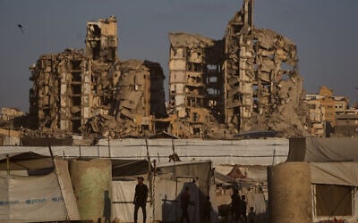 Palestinians walk past tents sheltering displaced civilians in Gaza City, August 17, 2026. (AP Photo/Jehad Alshrafi)
