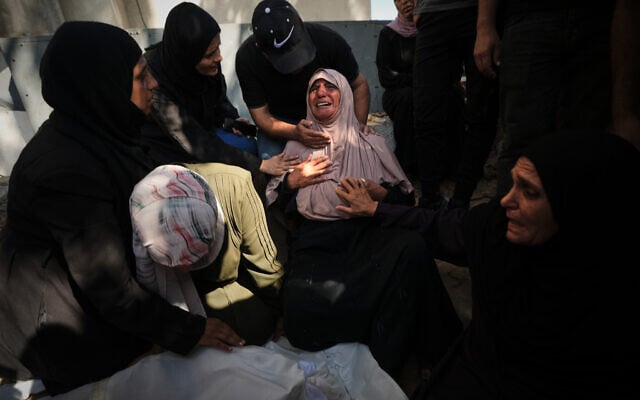 Mourners attend the funeral of Palestinians who were killed in an Israeli army strike on a cafe at the Gaza port the previous day, at Shifa Hospital in Gaza City, August 19, 2026. (AP/Jehad Alshrafi)