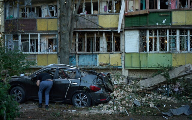 A local resident looks inside a destroyed car next to heavily damaged residential buildings after an overnight Russian attack, in Kyiv, Ukraine, August 20, 2026. (AP Photo/Francisco Seco) A local resident looks inside a destroyed car next to heavily damaged residential buildings after an overnight Russian attack, in Kyiv, Ukraine, August 20, 2026. (AP Photo/Francisco Seco)