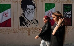 Women walk past a portrait of the late Iranian supreme leader Ayatollah Ali Khamenei, who was killed in US-Israel strikes on February 28, and images of the Iranian flag, on a sidewalk in downtown Tehran, Iran, August 20, 2026. (AP Photo/Vahid Salemi)