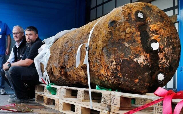 Members of a bomb disposal unit, Dieter Schwaetzler, left, and Rene Bennert sit next to 1.8 ton World War II bomb after defusing it in Frankfurt, Germany, September 3, 2017. (AP Photo/Michael Probst)