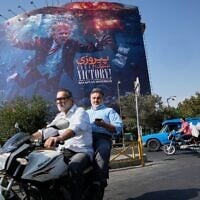 Motorcyclists pass a billboard depicting US President Donald Trump underwater amid explosions, with the words “Great Victory! Strait of Hormuz,” in Tehran, Iran, August 24, 2026. (AP Photo/Vahid Salemi)