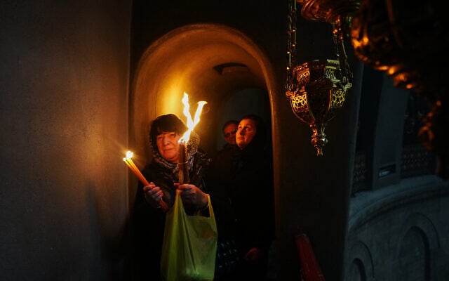 Christian Orthodox pilgrims hold up candles during the Holy Fire ceremony, at the Church of the Holy Sepulchre in the Old City of Jerusalem, April 11, 2026. (AP Photo/Mahmoud Illean)