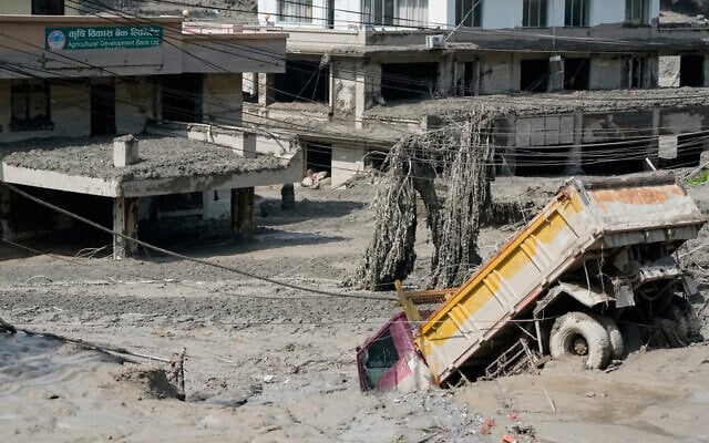 Damaged houses and vehicles are seen in the aftermath of flash floods along the Trishuli River in Nepal’s Nuwakot district, August 26, 2026. (AP/Niranjan Shrestha)