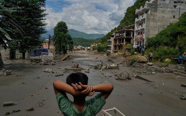 A boy looks at the devastation caused by flash flooding along the Trishuli River in Nepal’s Nuwakot district, August 26, 2026. (AP Photo/Niranjan Shrestha)