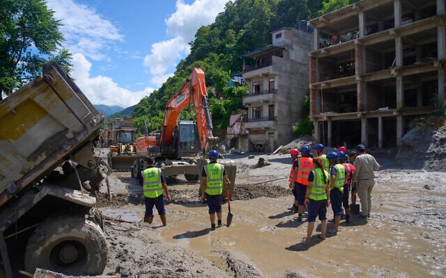 Earthmovers clear the debris from flash flooding in Nepal’s Nuwakot district, August 27, 2026. (AP/Niranjan Shrestha)