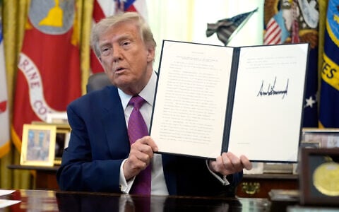 President Donald Trump holds up a signed executive order in the Oval Office of the White House, August 27, 2026, in Washington. (AP/Manuel Balce Ceneta)