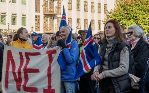 People hold a banner reading “No” as they listen to speakers at an “Afram Island,” “Forward, Iceland,” rally opposing the resumption of European Union accession talks at Austurvollur in Reykjavik, Iceland, August 27, 2026. (AP Photo/Marco Di Marco)