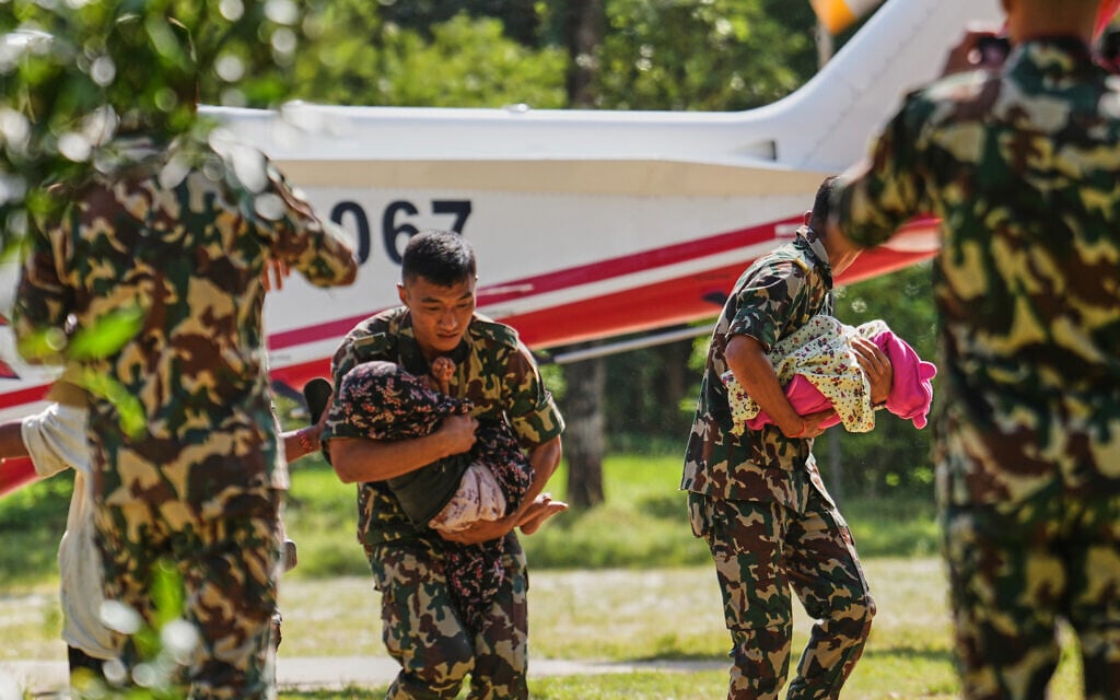 Nepalese army soldiers carry toddlers to safety alongside their family members after they are rescued by helicopter from an area cut off by flash flooding in Nepal’s Nuwakot district, August 28, 2026. (AP Photo/Rajesh Kumar Singh) Nepalese army soldiers carry toddlers to safety alongside their family members after they are rescued by helicopter from an area cut off by flash flooding in Nepal’s Nuwakot district, August 28, 2026. (AP Photo/Rajesh Kumar Singh)