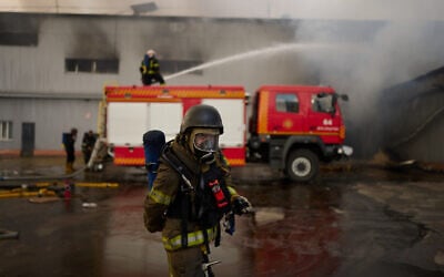 Firefighters work to extinguish a fire at a destroyed warehouse after Russian drone attacks on the outskirts of Kyiv, Ukraine, August 28, 2026. (AP Photo/Francisco Seco)
