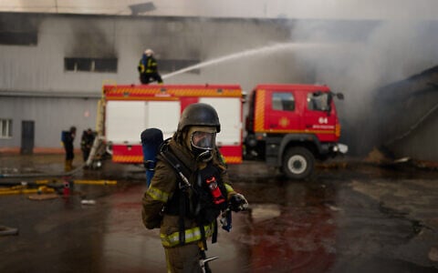 Firefighters work to extinguish a fire at a destroyed warehouse after Russian drone attacks on the outskirts of Kyiv, Ukraine, August 28, 2026. (AP Photo/Francisco Seco)