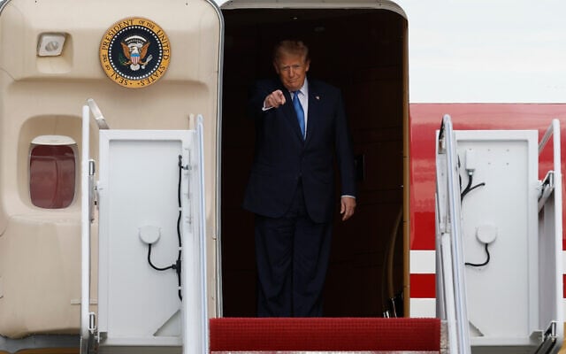 US President Donald Trump gestures as he disembarks Air Force One upon his arrival at Joint Base Andrews, Maryland, August 28, 2026. (AP Photo/Luis M. Alvarez)