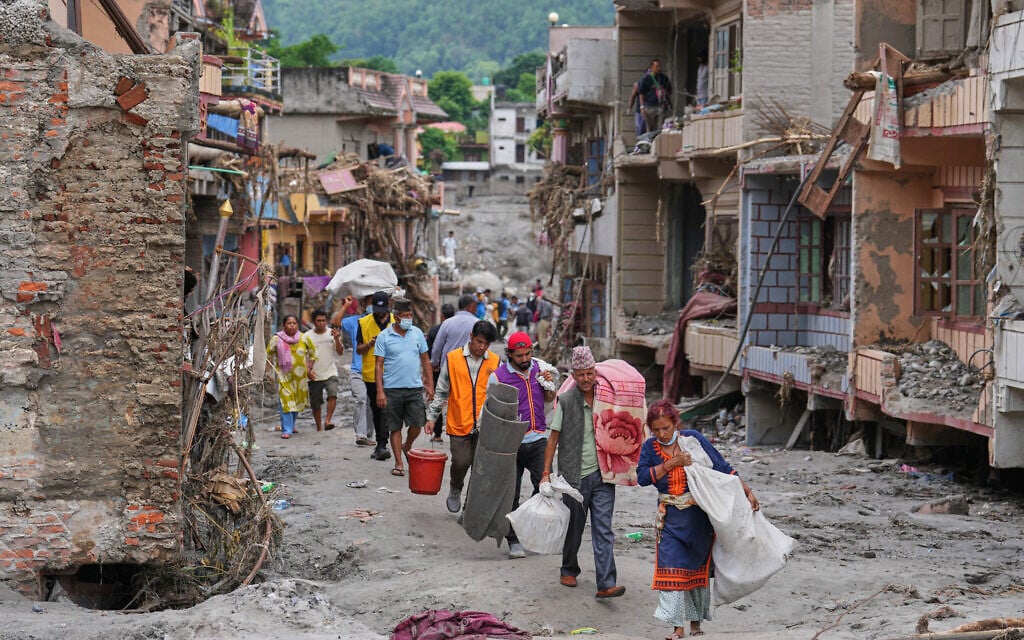 Residents carry their belongings salvaged from their damaged homes filled with mud and debris in Devighat, in Nepal’s Nuwakot district, August 29, 2026, following the flash floods. (AP Photo/Rajesh Kumar Singh) Residents carry their belongings salvaged from their damaged homes filled with mud and debris in Devighat, in Nepal’s Nuwakot district, August 29, 2026, following the flash floods. (AP Photo/Rajesh Kumar Singh)