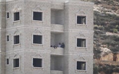 Israeli settlers are seen inside a Palestinian building under construction in the West Bank village of Qusra, August 29, 2026. (AP Photo/Majdi Mohammed)