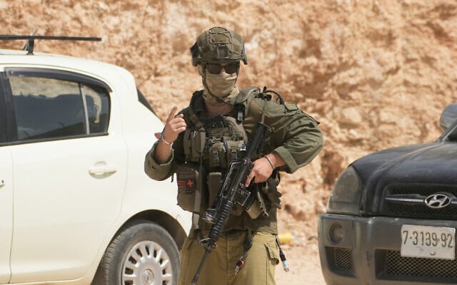 An IDF soldier patrols the site of an attack by settlers on Palestinian properties in the West Bank village of Qusra, August 29, 2026. (AP Photo/Majdi Mohammed) An IDF soldier patrols the site of an attack by settlers on Palestinian properties in the West Bank village of Qusra, August 29, 2026. (AP Photo/Majdi Mohammed)