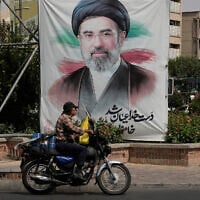 A man drives past a banner showing a portrait of Iranian Supreme Leader Ayatollah Mojtaba Khamenei, in downtown Tehran, Iran, August 31, 2026. (AP Photo/Vahid Salemi)