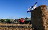 An Israeli flag flies over an agricultural field in the Gaza border community of Kibbutz Nahal Oz as members take part in traditional Shavuot celebrations, on May 22, 2026. (Tsafrir Abayov/Flash90)