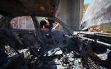 Illustrative: A Palestinian man inspects his burnt-out car after it was set alight by Israeli settlers, near Bethlehem, West Bank, on July 29, 2026. (Wisam Hashlamoun/FLASH90)