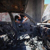 Illustrative: A Palestinian man inspects his burnt-out car after it was set alight by Israeli settlers, near Bethlehem, West Bank, on July 29, 2026. (Wisam Hashlamoun/FLASH90)