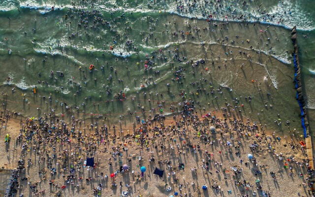 Ultra-Orthodox men bathe at a gender-segregated beach in Ashdod, August 3, 2026. (Chaim Goldberg/Flash90)