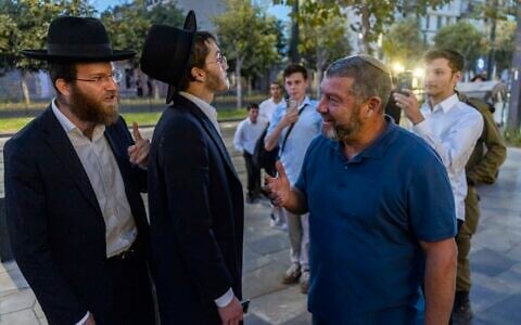 A protester shouts at former IDF Brig. Gen. Ofer Winter during a demonstration against an IDF recruitment conference for the Haredi community in Jerusalem, August 4, 2026. (Chaim Goldberg/Flash90)