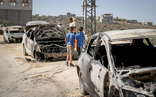 People inspect damaged cars after an attack allegedly by settler extremists in the village of Jalud, near the West Bank city of Nablus, August 4, 2026. (FLASH90)