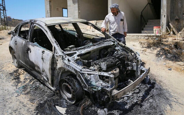 Palestinians inspect burned-out cars following an alleged attack by extremist Israeli settlers on Palestinian homes in the village of Jalud, south of Nablus in the West Bank, August 4, 2026. (Nasser Ishtayeh/Flash90)