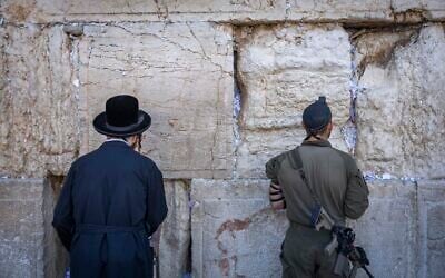 Two men, one an ultra-Orthodox civilian (left) and the other a soldier, pray at the Western Wall in Jerusalem’s Old city on August 6, 2026. (Chaim Goldberg/Flash90) Two men, one an ultra-Orthodox civilian (left) and the other a soldier, pray at the Western Wall in Jerusalem’s Old city on August 6, 2026. (Chaim Goldberg/Flash90)