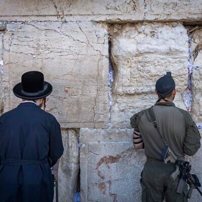 Two men, one an ultra-Orthodox civilian (left) and the other a soldier, pray at the Western Wall in Jerusalem’s Old city on August 6, 2026. (Chaim Goldberg/Flash90) Two men, one an ultra-Orthodox civilian (left) and the other a soldier, pray at the Western Wall in Jerusalem’s Old city on August 6, 2026. (Chaim Goldberg/Flash90)