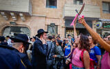 Haredi men protest outside the Basimta cafe for opening on Shabbat while secular counterprotesters stand in front of them, in Jerusalem on August 8, 2026. (Oren Ben Hakoon/Flash90)