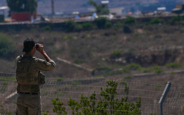 An IDF soldier look at southern Lebanon from northern Israel, August 10, 2026. (Ayal Margolin/FLASH90)