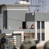 Israeli activists and Palestinian residents stand on the roof of a house besieged by Israeli settlers in the village of Qusra, south of Nablus, West Bank, on August 14, 2026. (FLASH90/ File)