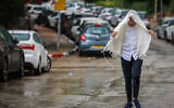 People walk in the rain in Jerusalem, August 15, 2026. (Yossi Zamir/Flash90)