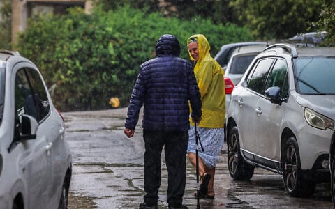 People walk in the rain in Jerusalem, August 15, 2026. (Yossi Zamir/Flash90)