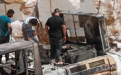 Palestinians inspect fire damage that residents said was caused by Israeli settlers in the Wadi al-Rakhim area of Yatta, south of Hebron in the West Bank, August 21, 2026. (Wisam Hashlamoun/Flash90)