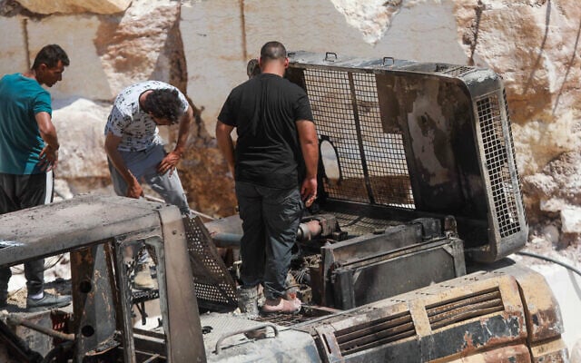Palestinians inspect fire damage that residents said was caused by Israeli settlers in the Wadi al-Rakhim area of Yatta, south of Hebron in the West Bank, August 21, 2026. (Wisam Hashlamoun/Flash90)
