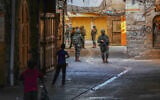 Israeli security forces guard a group of Jewish Israelis as they tour the West Bank city of Hebron, August 22, 2026. (Wisam Hashlamoun/Flash90)