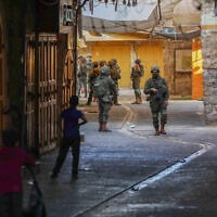 Israeli security forces guard a group of Jewish Israelis as they tour the West Bank city of Hebron, August 22, 2026. (Wisam Hashlamoun/Flash90)