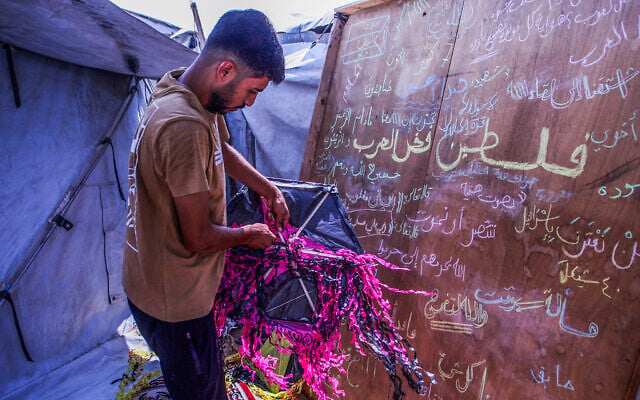 A Palestinian man makes kites inside a tent in Khan Younis, in the southern Gaza Strip, August 29, 2026. (Saeed Mohammed/Flash90)