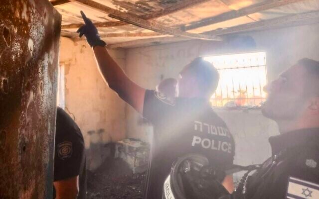 Arson investigators from Israel Police and the Fire and Rescue Service inspect the site of a reported settler arson attack on a Palestinian home in the southern West Bank village of Khillet al-Farra, August 20, 2026, which Israeli authorities say was caused by an electrical failure. (Israel Police)