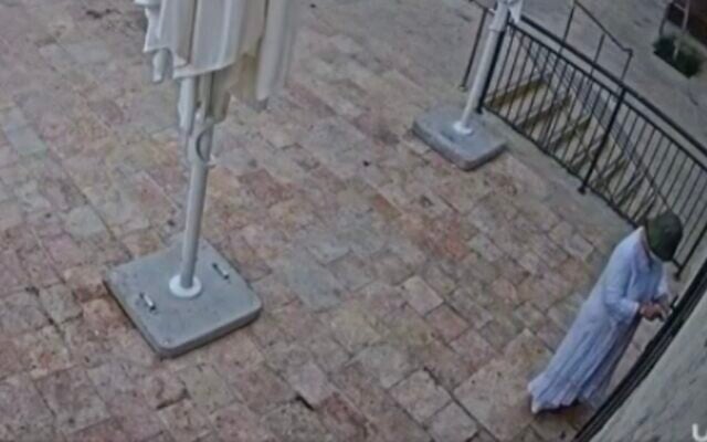 CCTV footage shows a masked individual gluing lock of Basimta cafe in Jerusalem, August 15, 2026. (Screen grab/Channel 12 via X)