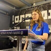 Shir Matias, whose parents Deborah (Shachar) and Shlomi were killed protecting her brother Rotem at their Kibbutz Holit home in the Hamas-led onslaught of October 7, 2023, speaks at an anti-government rally in Habima Aquare, Tel Aviv, August 1, 2026. (Movement for Quality Government in Israel)