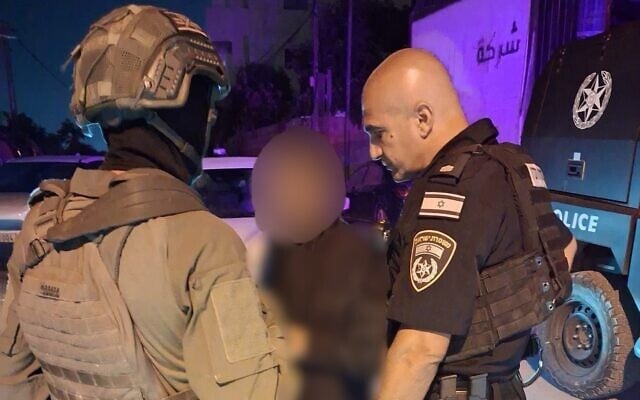 Police escort a woman they say was forcibly taken by relatives from Israel to Hebron, August 13, 2026. (Israel Police)