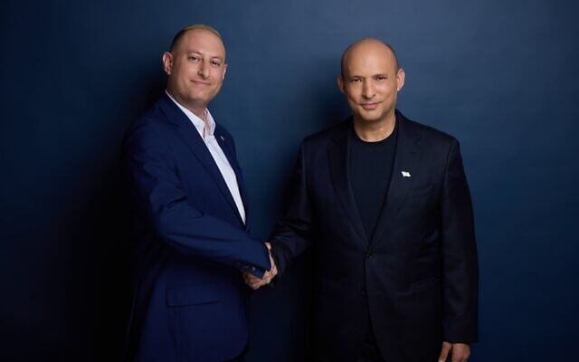 Candidate Jeremy Saltan (left) and former prime minister Naftali Bennett shake hands in an undated photo released by the B'Yachad party. (Courtesy)