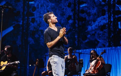 Former hostage Sagui Dekel-Chen performs the songs he composed in captivity, on the lawn of Kibbutz Nir Oz as part of the Israel Festival on August 10, 2026 (Orit Pnini) Former hostage Sagui Dekel-Chen performs the songs he composed in captivity, on the lawn of Kibbutz Nir Oz as part of the Israel Festival on August 10, 2026 (Orit Pnini)