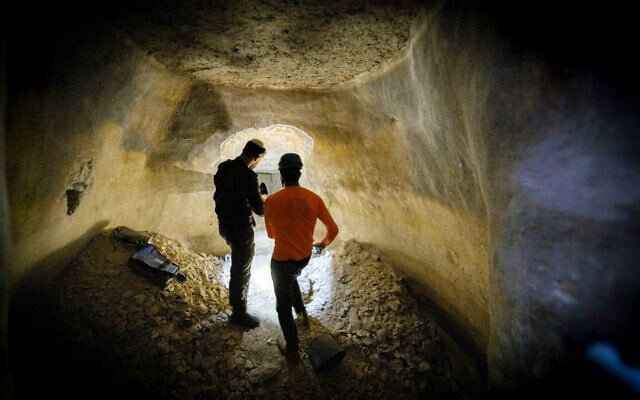 Security personnel operate inside a tunnel that police say was hidden in an ancient water cistern in the central West Bank Palestinian village of al-Jib, in a picture published on September 10, 2026. (Israel Police)
