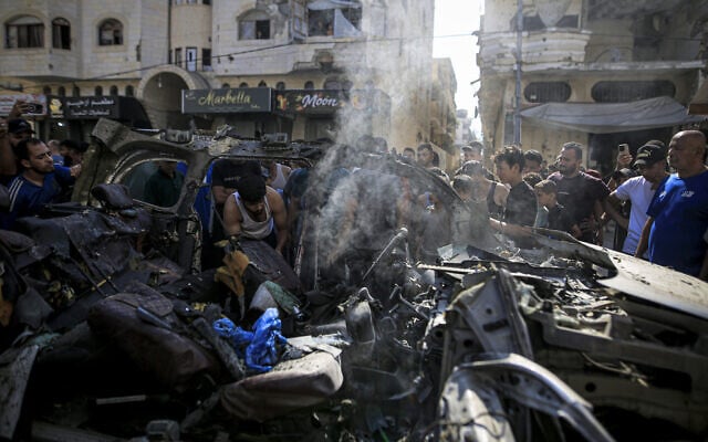 Palestinians gather to inspect the wreckage and damage at the site of an Israeli attack on a vehicle in the Tel al-Hawa neighborhood of Gaza City, on September 13, 2026 (Saeed M. M. T. Jaras / Anadolu via Reuters)