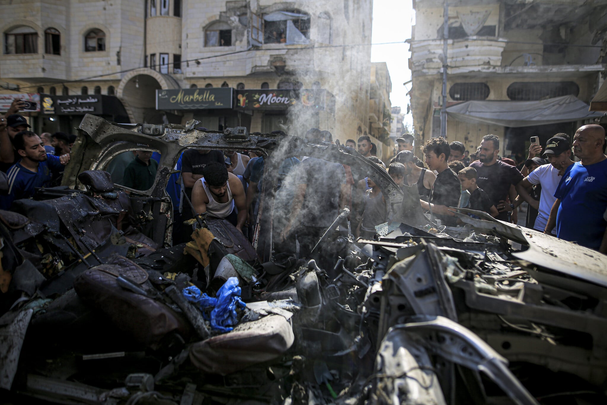 Palestinians inspect the wreckage of a vehicle struck by an Israeli strike in the Tel al-Hawa neighborhood of Gaza City, September 13, 2026