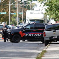 Police officers talk near the scene of a shooting where a police officer was shot outside a Yom Kippur gathering at Sons of Jacob Synagogue in Belleville, Ontario, Canada, September 21, 2026. (Patrick Doyle/Reuters)